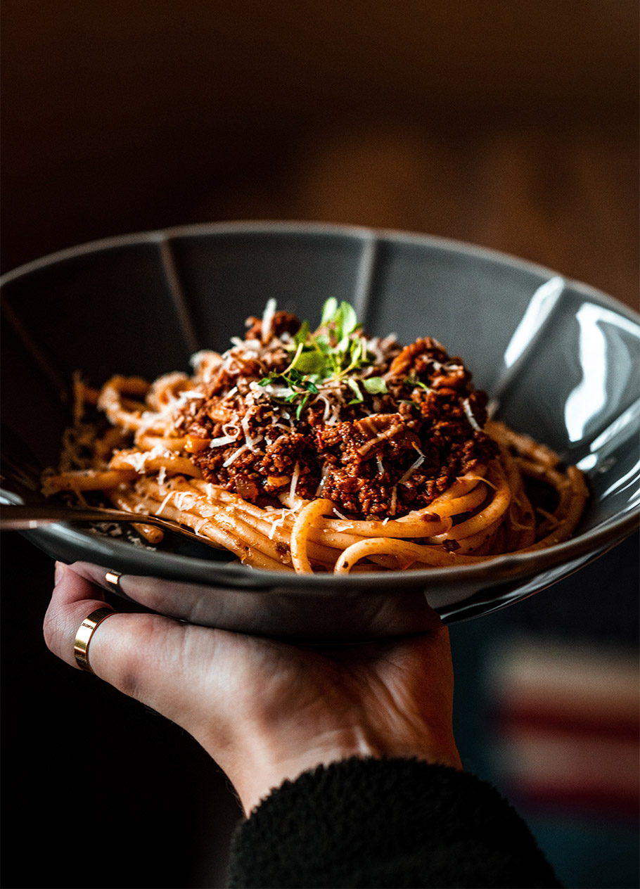 Person holding a bowl of fresh pasta.